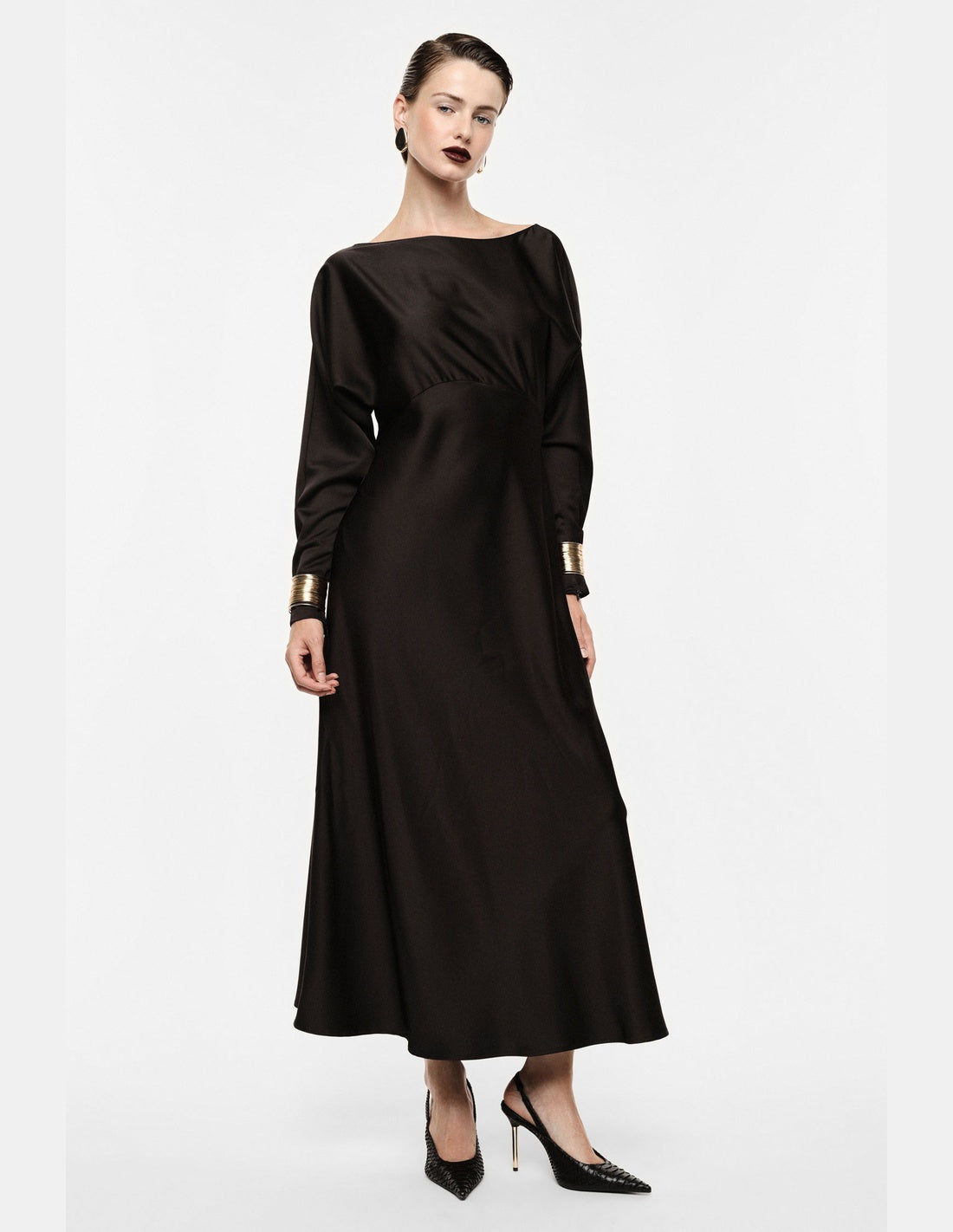 Robe longue en crêpe satin col bateau manchettes dorées, portée de profil